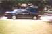 2002 Ford Crown Victoria - A dark sedan is parked in a driveway with a blue SUV behind it. The sedan appears to be a 2002 Ford Crown Victoria.