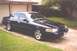 2002 Ford Crown Victoria - A black 2002 Ford Crown Victoria is parked in front of a garage.