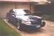 2002 Ford Crown Victoria - Front 3/4 view of a 2002 Ford Crown Victoria parked in front of a garage.