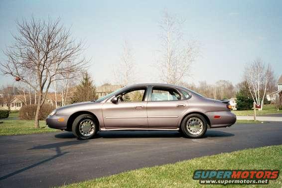 1996 Ford Taurus sedan, purple, parked on asphalt driveway, side view