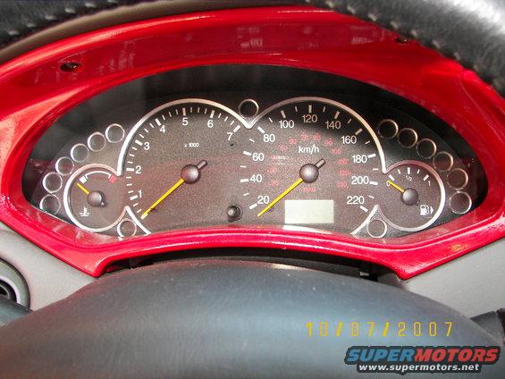 2002 Ford Focus dashboard with speedometer and tachometer, red trim around gauges