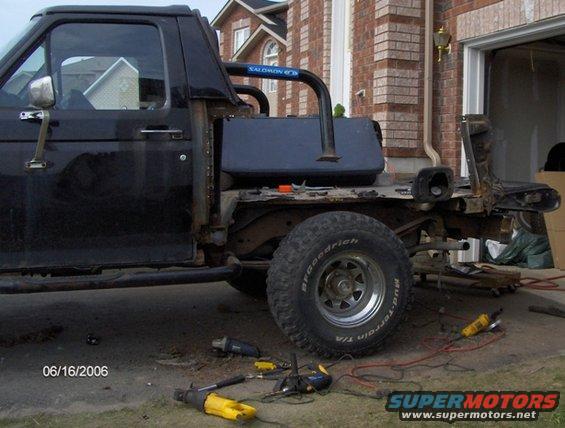 Side view of a black pickup truck chassis with a roll bar and exposed frame