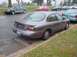 1996 Ford Taurus - A gray Ford Taurus is parked on the street, showing its rear end and a portion of its side.