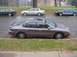 1996 Ford Taurus - A 1996 Ford Taurus is parked on the side of the road with other vehicles in the background.