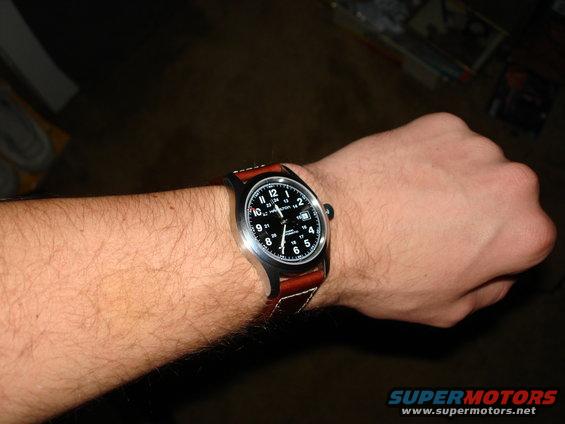 Hamilton watch with brown leather strap on a hairy arm. Text on dial reads 'HAMILTON' and 'AUTOMATIC'