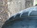 1999 Ford Mustang - Close-up of a damaged tire, showing tread wear and sidewall cracks.