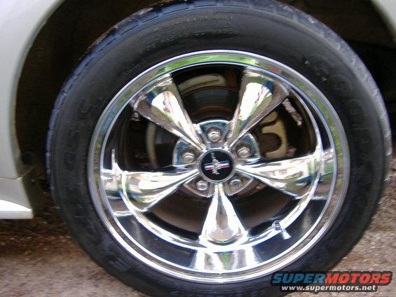 Chrome five-spoke wheel with Mustang logo on 1999 Ford Mustang