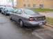 1996 Ford Taurus - A 1996 Ford Taurus is parked on a wet street next to another car, with a brick building in the background.