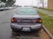 1996 Ford Taurus - Rear view of a 1996 Ford Taurus sedan parked on a wet street.