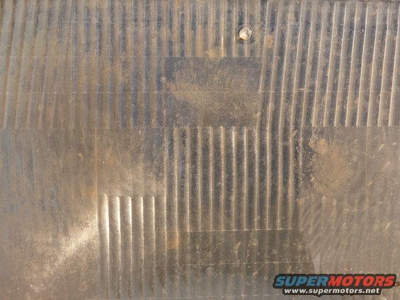 Headlight lens with vertical fluting and a small circular stud