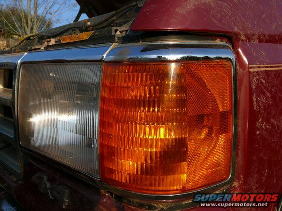Red 1988 Ford Bronco front headlight and amber turn signal assembly