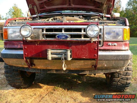 1987 Ford Bronco front end with aftermarket winch and lights. 4x4 badge visible