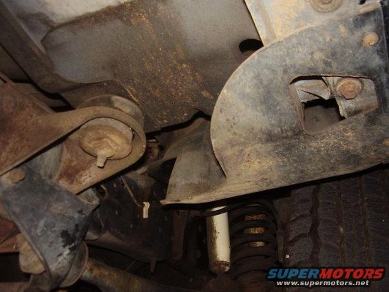 Close-up of rusty suspension parts and shock absorber under a vehicle
