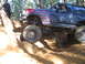 1989 Ford Bronco - This modified Ford Bronco navigates a challenging off-road trail with steep inclines and rocky terrain.