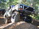 1989 Ford Bronco - Modified 1979 Ford F-150 navigates a steep dirt incline in a forest setting, with another vehicle visible behind.