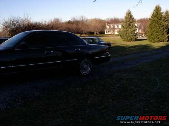 Black 1997 Ford Crown Victoria sedan, side view, with chrome trim and alloy wheels