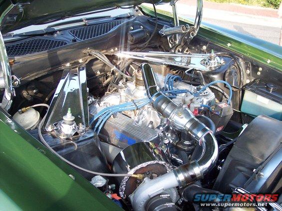 Engine bay with chrome valve covers, turbocharger, and blue spark plug wires
