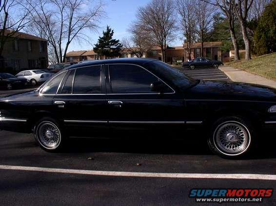 1997 Ford Crown Victoria sedan, side view, black paint, chrome wheels