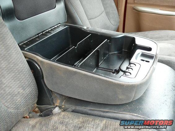 Center console storage compartment with dividers, gray fabric upholstery, and black plastic lid