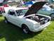 1973 Ford Mustang - A white 1965 Ford Mustang coupe is displayed with its hood open at an outdoor car show.