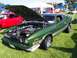 1973 Ford Mustang - A green 1973 Ford Mustang Mach 1 is displayed with its hood open, revealing the engine bay.