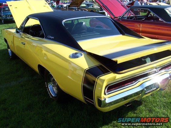 Yellow 1970 Dodge Charger rear quarter view with black stripes and vinyl roof