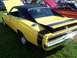 1973 Ford Mustang - A yellow 1970 Dodge Charger with black racing stripes and a black vinyl roof is displayed on a grassy field with other vehicles.