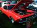 1973 Ford Mustang - A red 1970 Plymouth Barracuda is displayed with its hood open, showing the engine and a "Shaker" scoop.