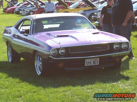 Purple 1970 Dodge Challenger parked on grass with other cars in background