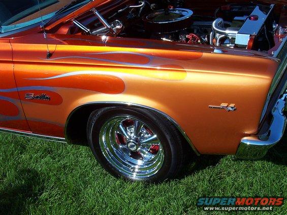 Orange hot rod with silver flames, chrome wheels, and exposed engine