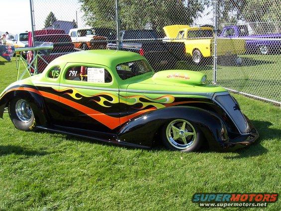 Custom hot rod with green and black paint, orange and yellow flames, and a hood scoop