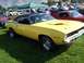 1973 Ford Mustang - A yellow 1970 Plymouth Barracuda is displayed at an outdoor car show.