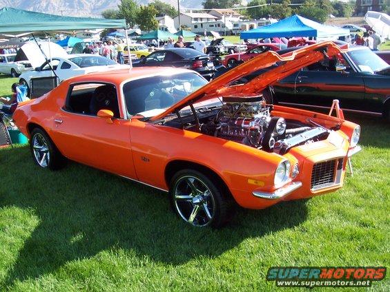 Orange 1970 Chevrolet Camaro with hood open, showing a supercharged engine