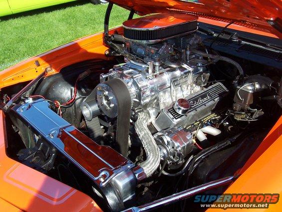Chrome Edelbrock intake manifold and Weiand supercharger on a V8 engine. The engine bay is orange