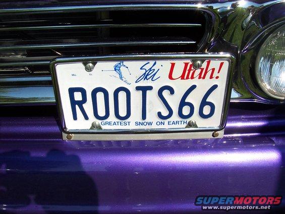 Purple car's front end with a Utah license plate that says ROOTS66 and has a skier graphic