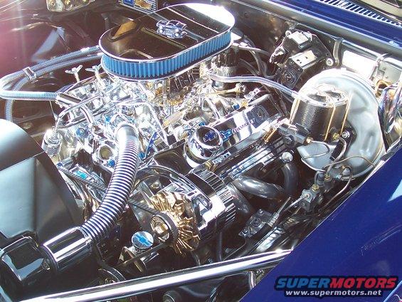 Close-up of a shiny V8 engine with chrome parts and a blue air filter