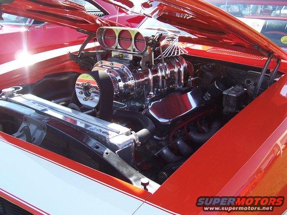 Engine bay with chrome supercharger and triple carburetors