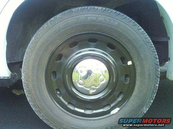 Close-up of a black steel wheel with a chrome Ford hubcap on a vehicle