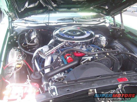 Engine bay of a 1972 Ford Ranchero with a 351 V8 engine, chrome air cleaner, and blue spark plug wires