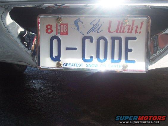 Close-up of a Utah license plate reading 'Q-CODE' mounted on a chrome bumper