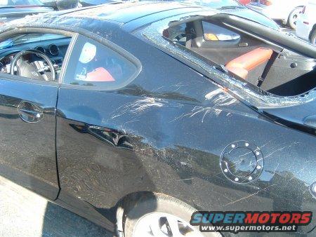 black 2007 Hyundai Tiburon with shattered rear window and body damage