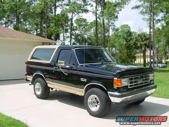 Black and tan 1987 Ford Bronco parked in driveway