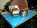 1996 Ford Bronco - Two metal pulleys and a c-clip are placed on blue tape in front of a belt sander.