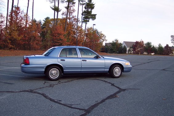 Blue 2001 Ford Crown Victoria sedan parked in an empty lot
