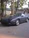 1991 Mazda RX-7 - A matte black Mazda RX-7 is parked on a residential street with autumn leaves on the ground.
