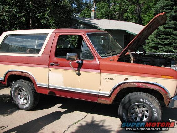 Red and tan 1986 Ford Bronco, 3/4 front view, hood open