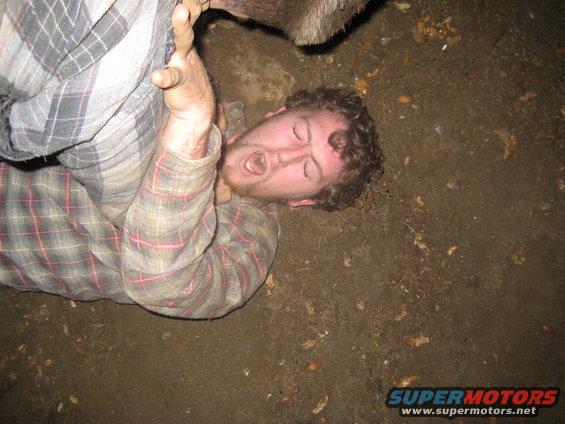 Man on ground with plaid shirt, Supermotors logo visible
