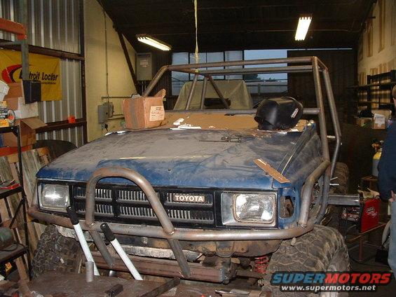 Front view of a blue Toyota with a custom roll cage and off-road bumper