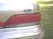 1994 Ford Crown Victoria - Close-up of the rear of a gold 1994 Ford Crown Victoria, showing the taillight and Ford emblem.