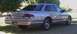1994 Ford Crown Victoria - Rear view of a 1994 Ford Crown Victoria sedan parked on grass with trees in the background.